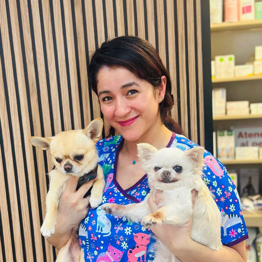 Foto de la auxiliar veterinaria de la clínica veterinaria El Jardín con dos perros en brazos.